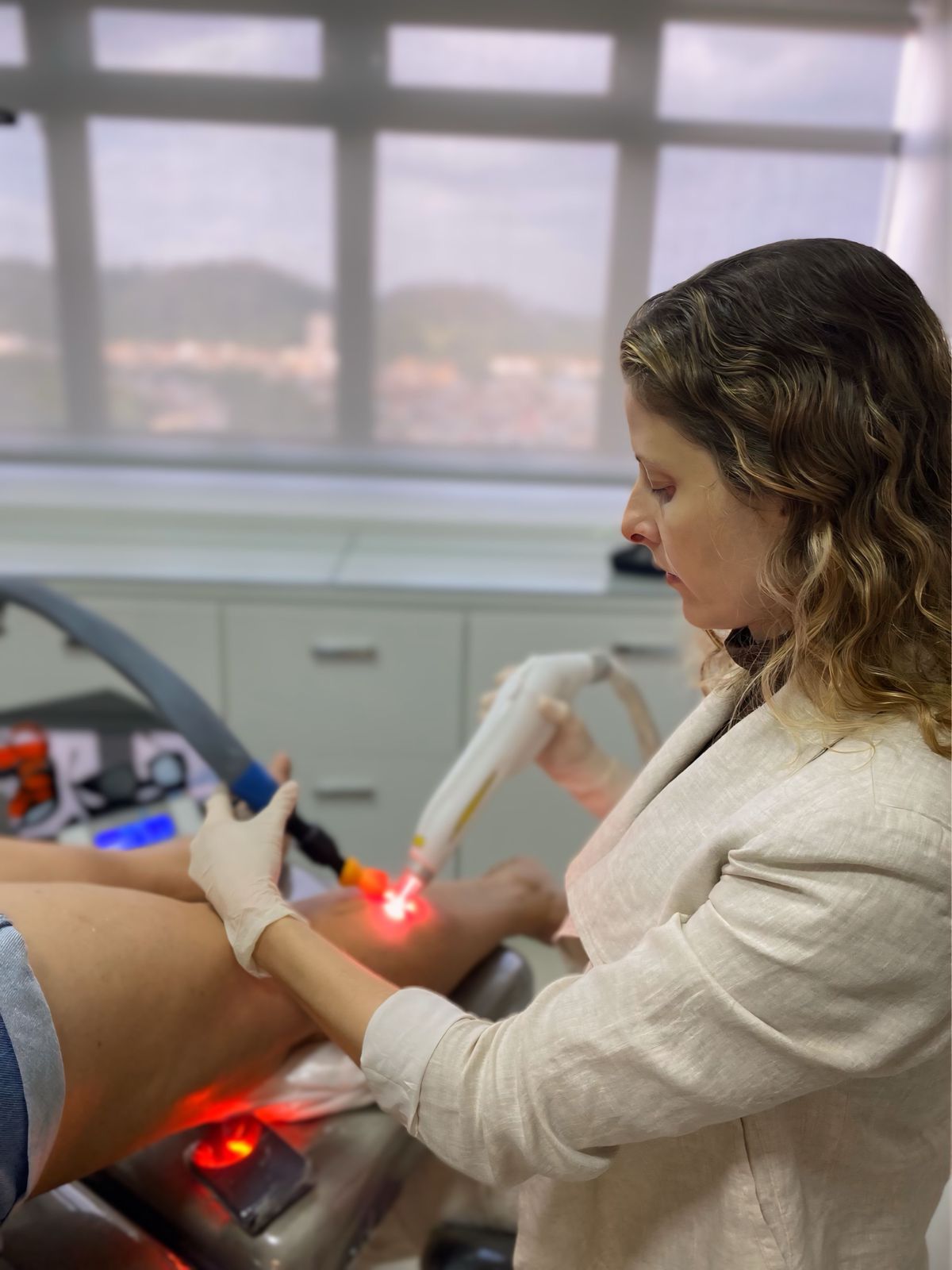 Dra. Milena realizando procedimento vascular em consultório